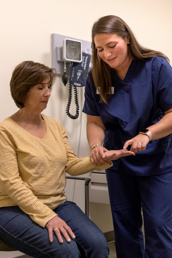 A female student assessing a standardized patient