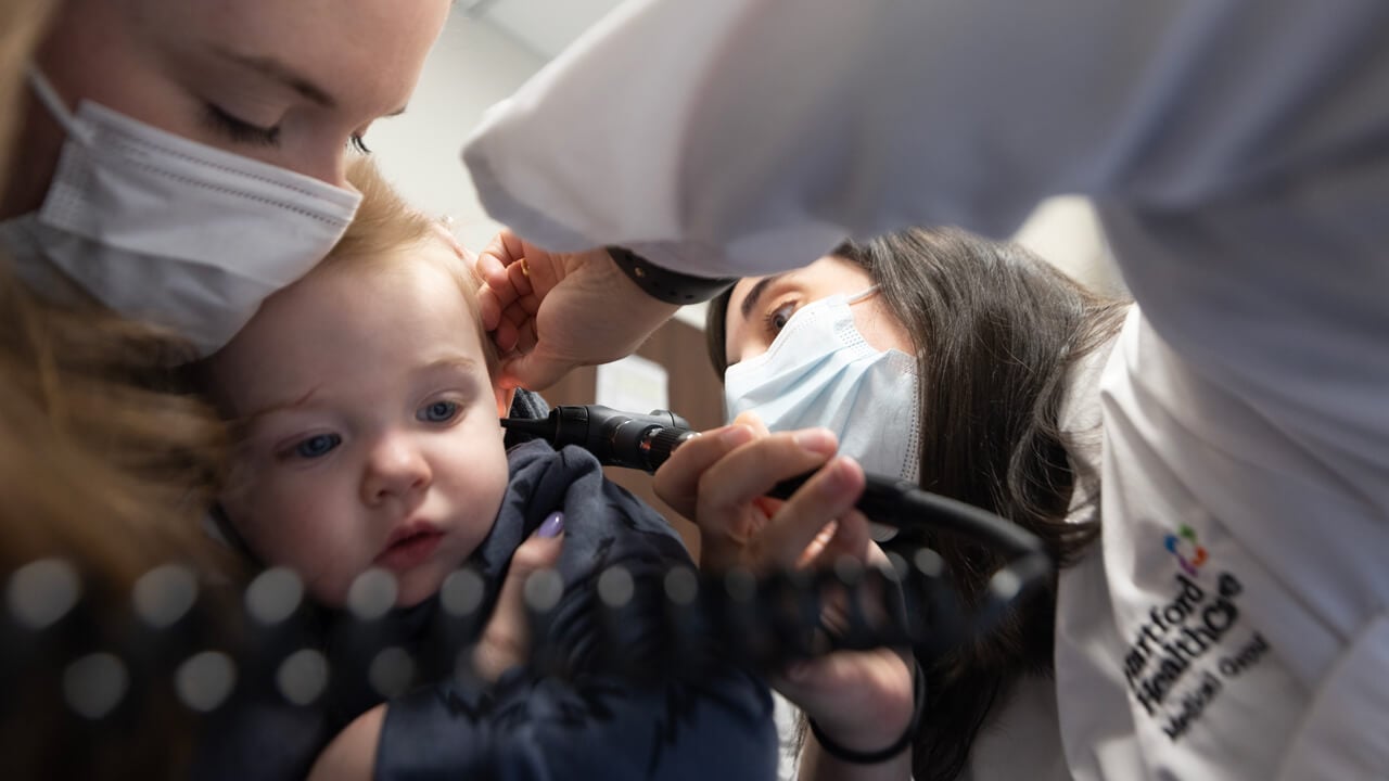 Doctor checks the health of a child's ear.