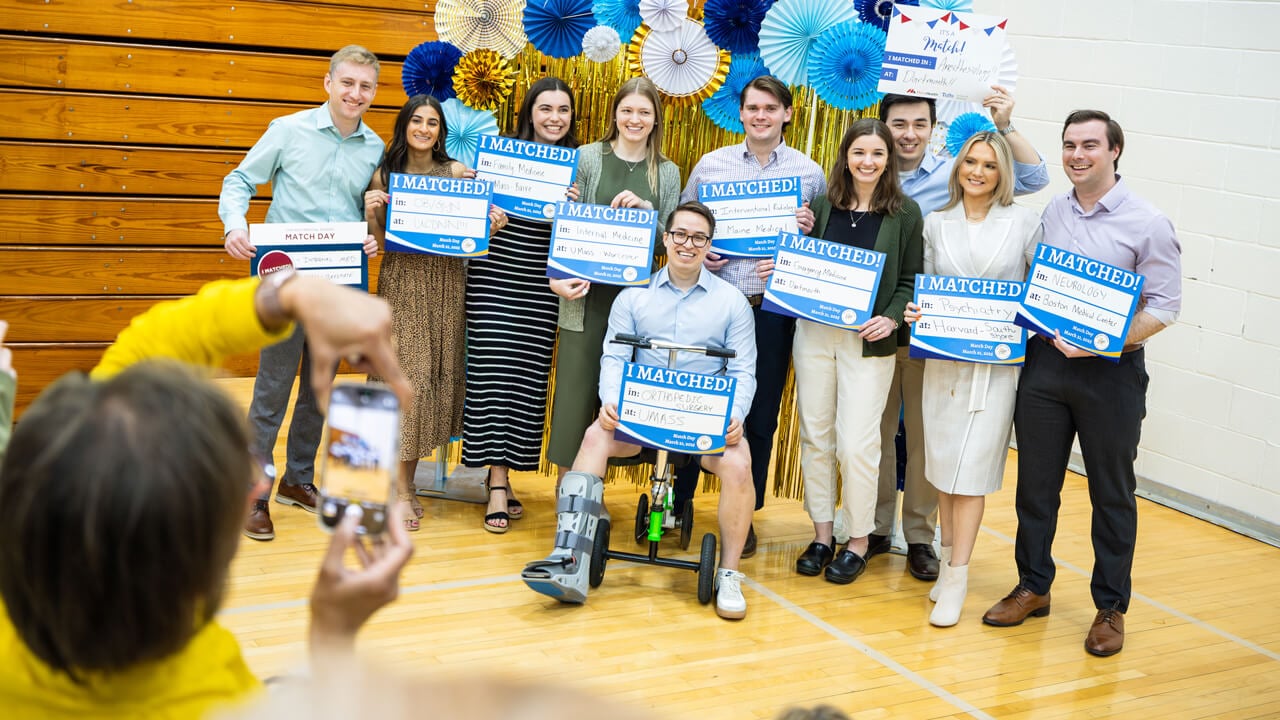 9 Quinnipiac medical students pose for a photo with their Match Day "I Matched" signs