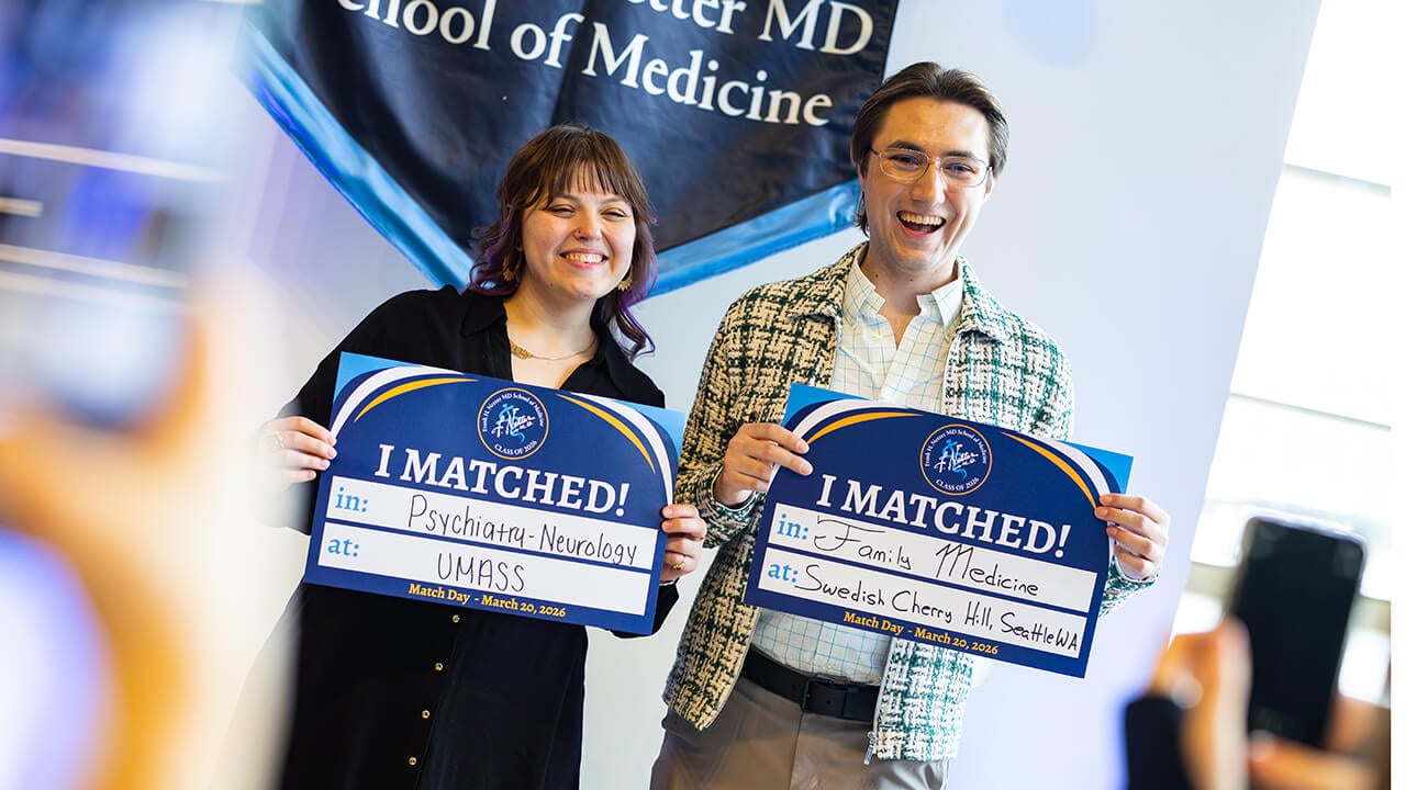 Two students holding up their match signs on Match Day