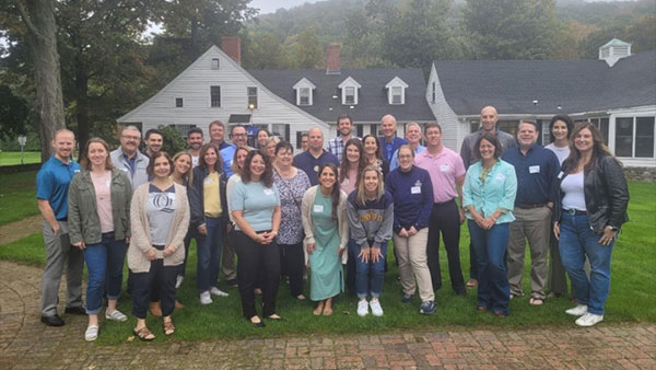 Faculty and staff alumni pose for a picture at Alumni Gardens on the Mount Carmel campus.