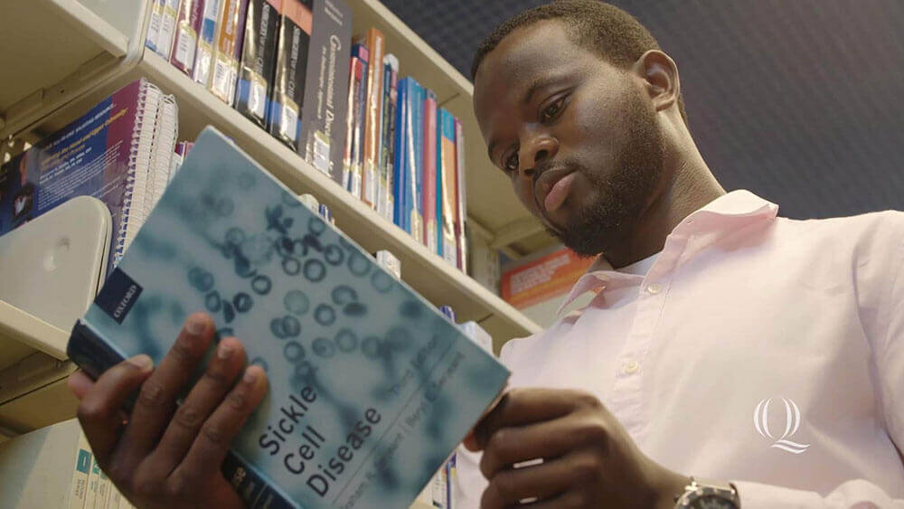 Azeez Akinlolu reads a book on sickle cell disease, starts video
