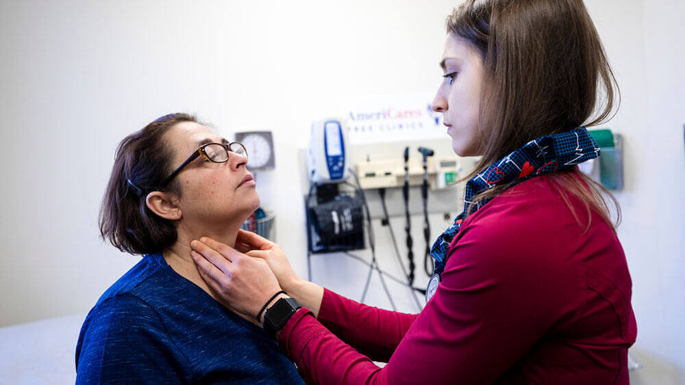 A medical student checks the pulse of a patient at a free health clinic in Bridgeport