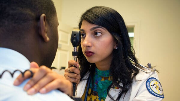 A medical student examines a standardized patient