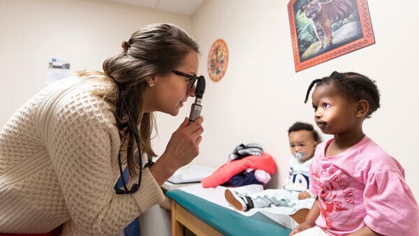 A medical student examines a pediatric patient