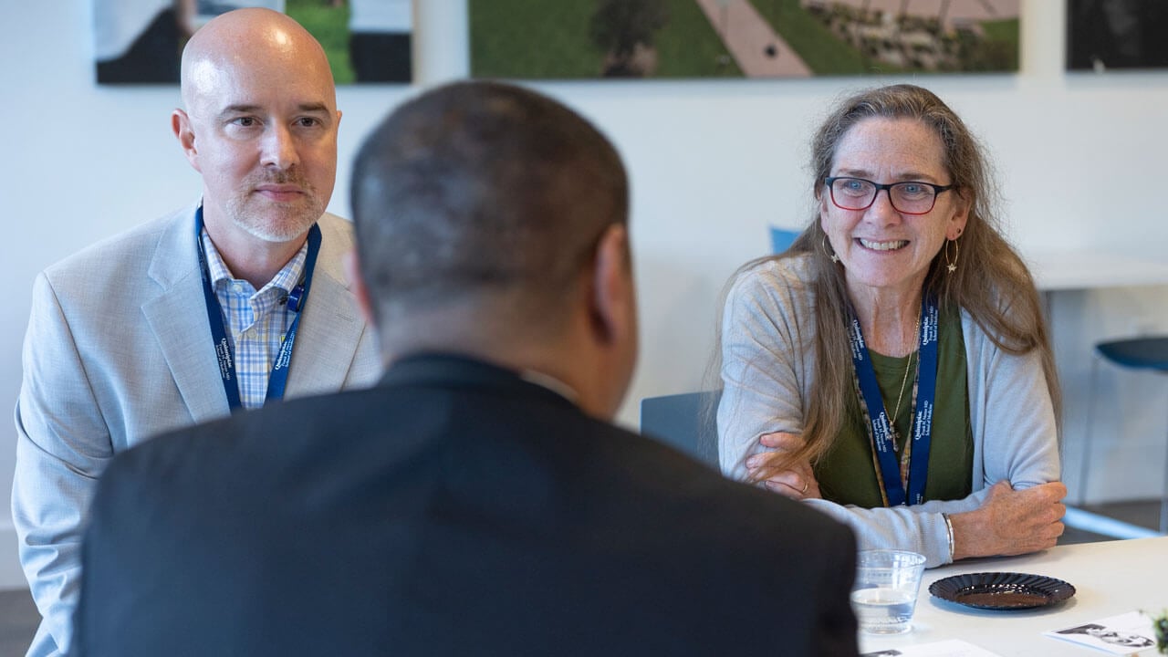 School of Medicine faculty members socialize at an event.