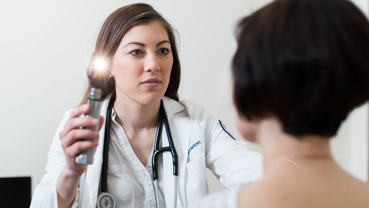 Quinnipiac medical student examines her patient's eyes during a check-up procedure.